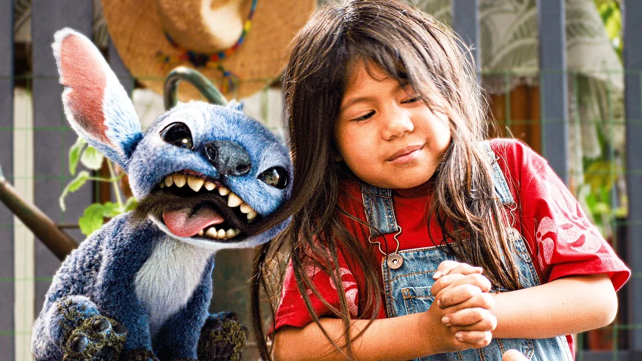 Stitch grins beside Lilo, played by Maia Kealoha, in a sunlit scene from Disney’s live-action Lilo & Stitch.