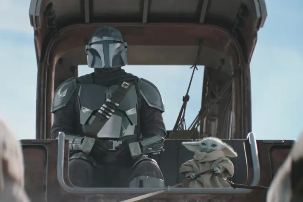 Din Djarin and Grogu ride together on a vehicle in The Mandalorian.