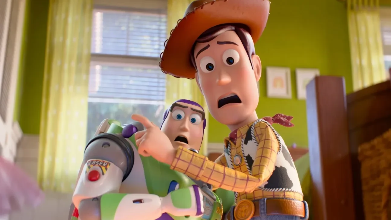 Woody points off-screen with an alarmed expression while Buzz Lightyear looks on in a child's green-walled bedroom in Toy Story 5.
